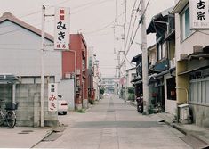 an empty street with buildings and bicycles parked on the side