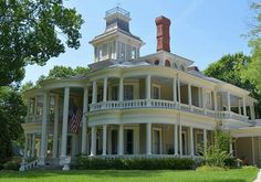 a large white house sitting on top of a lush green field