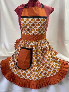 an orange apron with pumpkins on it