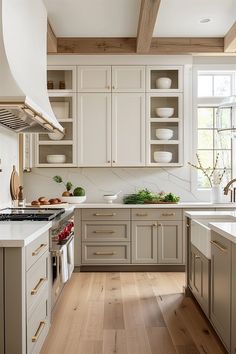 a kitchen with white cabinets and wood floors