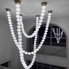 a chandelier with lights hanging from it's sides in front of a window