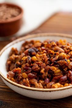 a white bowl filled with food on top of a wooden table