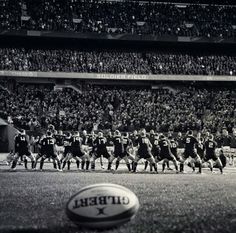 an old photo of a football game being played in front of a large stadium full of people