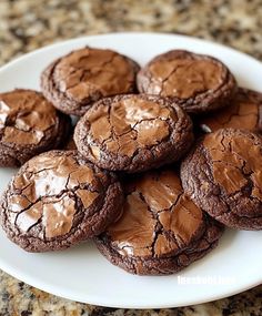 a white plate topped with chocolate cookies covered in frosting