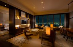 a living room filled with furniture and a large window overlooking the city lights at night