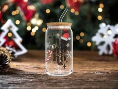 a glass jar with a straw in it sitting on a table next to christmas decorations