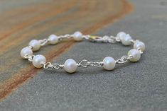 Pearl bracelet. Sterling Silver Stacking Bracelet. Freshwater pearls and sterling silver components went into this dainty bracelet. The pearls separated by chain links are ivory and potato-shaped at 5.5 mm wide. A sterling silver lobster clasp is used as closure in the handmade bracelet. A perfect stacking bracelet that measures 7 1/2 inches (19 cm) long including a short extender chain finished with a single pearl dangle. The sample bracelet fits 5 1/4 to 5 3/4inch wrist. Pearl is a June birthstone. This is a great bracelet to get your arm party started. Pictures are enlarged to show detail. You will receive a remake of this beautiful freshwater pearl sterling silver bracelet. The bracelet ships in a small organza bag inside a gift box, ready to give... or keep!   Additional WireAndPearl Elegant White Sterling Silver Nickel-free Bracelet, Elegant White Wire Wrapped Pearl Bracelet, Elegant White Nickel-free Pearl Bracelet, Elegant Pearl Bracelets Nickel Free, Elegant Pearl Bracelet Nickel Free, Sterling Silver Stacking Bracelets, Silver Pearl Jewelry, Small Jewelry Box, Dainty Bracelets