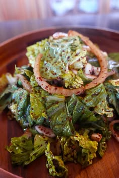 a wooden plate topped with lettuce and onions