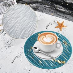 there is a cup of coffee with a heart on the saucer next to it