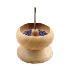 a wooden bowl with a blue dot in the center and a metal tip sticking out of it