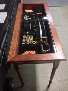 a wooden table topped with lots of items on top of a black cloth covered floor