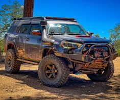 a truck parked in the dirt near a tree