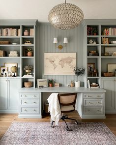 an office with blue bookcases and white desk in the center, along with a map on the wall