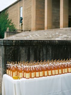 several bottles of honey sit on a table in front of an old building with columns