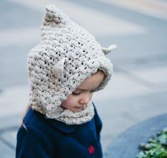 a small child wearing a crocheted hat and scarf