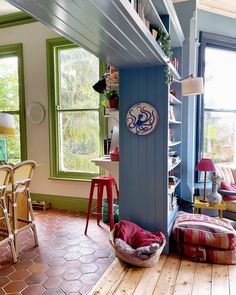 a living room filled with lots of furniture next to a large open window on top of a hard wood floor