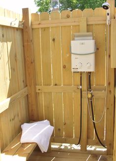 an outdoor shower in the middle of a wooden fence