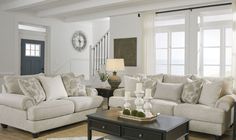 a living room filled with furniture and a clock on the wall