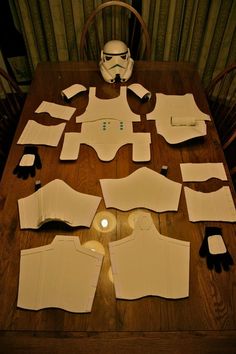 a wooden table topped with lots of paper cut out to look like darth vader