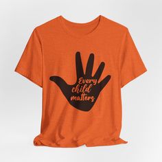 Show your support and raise awareness with our Every Child Matters Orange Shirt collection, designed to honor the lives of Indigenous children, featuring the Every Child Matters slogan with various indigenous graphics and designs. These shirts give a powerful message of unity and support for indigenous communities. Perfect for casual wear or as a statement piece during Indigenous Peoples' Day celebrations. Product features - Unisex fit for versatile styling - Made with lightweight and breathable 100% cotton - Classic crew neckline for easy accessorizing - Manufactured in a humane and sustainable way by Bella+Canvas - Variety of fabric blends for different color options Care instructions - Machine wash: cold (max 30C or 90F) - Non-chlorine: bleach as needed - Tumble dry: low heat - Iron, st Orange Short Sleeve T-shirt With Slogan, Orange Cotton T-shirt With Slogan, Casual Graphic T-shirt For Awareness Events, Casual Graphic Print T-shirt For Awareness Events, Casual Pre-shrunk T-shirt For Awareness Events, Casual T-shirt With Graphic Print For Awareness Events, Cotton Graphic Print Shirt For Awareness Events, Graphic Print Tops For Awareness Events, Cotton Shirt With Graphic Print For Awareness Events