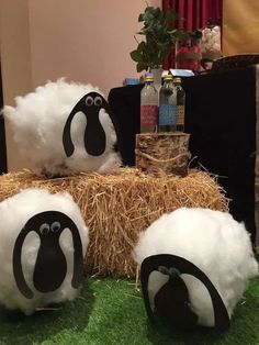 three fake sheep are sitting on hay bales