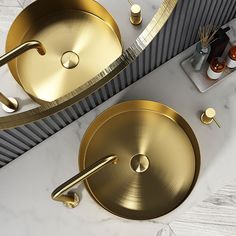 two gold sinks on a marble counter top