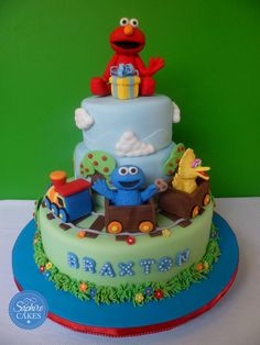 the birthday cake is decorated with an elmo and sesame street characters on it's top