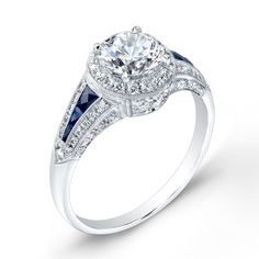 a diamond and blue sapphire engagement ring with two side stones on the band, set in white gold