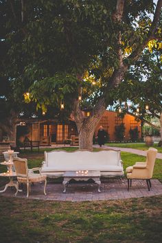 an outdoor seating area in the middle of a park with chairs and tables around it