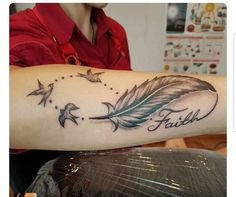 a woman with a tattoo on her arm that says faith and birds flying around it