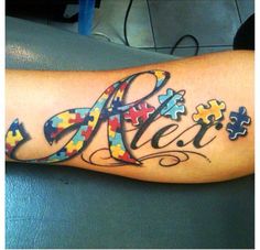 a person with a tattoo on their arm that has puzzle pieces and the word alex