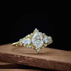 a three stone ring sitting on top of a wooden table