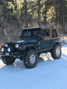 a jeep parked in the snow near some trees