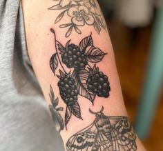 a close up of a person's arm with a tattoo on it and flowers