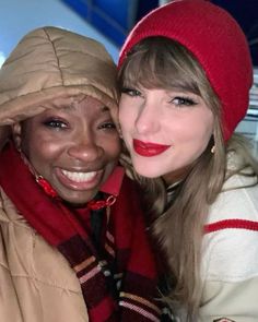 two women posing for the camera with one woman wearing a red hat and scarf on her head