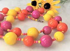 "30\" Brite Bubble Beaded Orange/Pink/Yellow Multi Lucite Necklace & Matching Cluster Clip On Earrings Pink/Yellow/Orange Alternating Beads with Mini Beads Large Beads Measure 3/4\" in Diameter Smaller Beads Measure 5/8\" in Diameter Silver Tone Lobster Clasp Cluster Clip On Earrings Measure 1 1/8\" in Diameter Made in USA Necklace/Earrings Set 42.00 Necklace Only 29.00 Cluster Earrings Only 15.00 COMPLIMENTARY DOMESTIC SHIPPING" Yellow Round Bead Necklaces For Summer, Yellow Round Beads Necklace For Summer, Yellow Beaded Necklaces With Large Beads For Summer, Summer Yellow Beaded Necklaces With Large Beads, Yellow Wooden Beads For Jewelry Making, Vibrant Yellow Beaded Jewelry, Colorful Beaded Necklaces In Yellow, Vibrant Pink Round Bead Jewelry, Vibrant Pink Round Beaded Jewelry