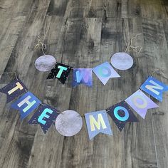 a wooden floor that has some paper cut out to spell out the word mom on it