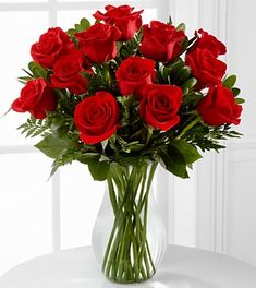 a vase filled with red roses on top of a table