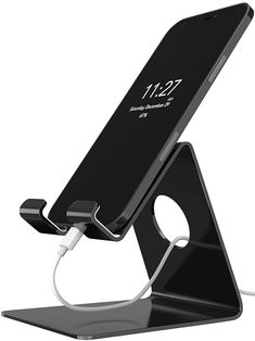 an image of a cell phone charging on a stand with the charger plugged in