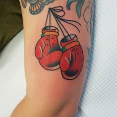 a tattoo with two boxing gloves hanging from it