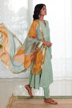 Mint green cotton lurex flared kurta with silver stripes and dotted motif woven detail. Paired with pants and ombre dupatta highlighted with hand embroidered gota -fringe border.
Component: 3
Embroidered
Neckline: Round
Sleeve Length: Long
Fabric: Anarkali: Cotton Lurex; Dupatta: Organza; Lining: Cotton; Pant: Cotton Silk
Color: Green
Tassel tie-up neck
Fringe dupatta - Aza Fashions Green Anarkali, Kurta Set For Women, Yellow Ombre, Blouse Designs Indian, Organza Dupatta, Embroidered Neckline, Designs For Dresses, Silk Pants, Indian Ethnic Wear