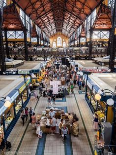 an indoor market with many people shopping in it