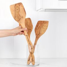 two wooden utensils in a glass vase with the words happy mother's day written on them