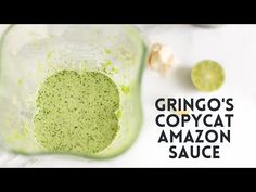 a green smoothie in a blender with the text grino's copycat amazon sauce