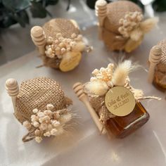 some little bottles with flowers on them sitting on a table next to other small jars