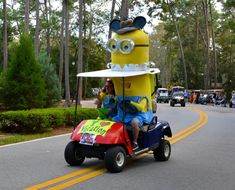 a person in a minion golf cart driving down the street