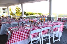 an outdoor dining area with red and white checkered tablecloths on the tables