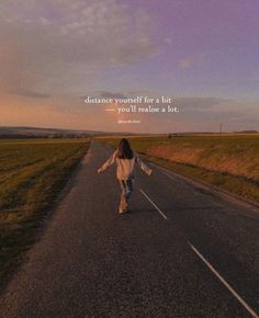 a woman is walking down the road with her arms spread out in front of her