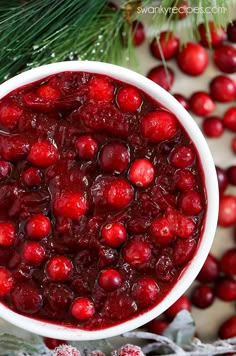 cranberry sauce in a white bowl surrounded by christmas decorations