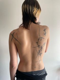 the back of a woman with tattoos on her body